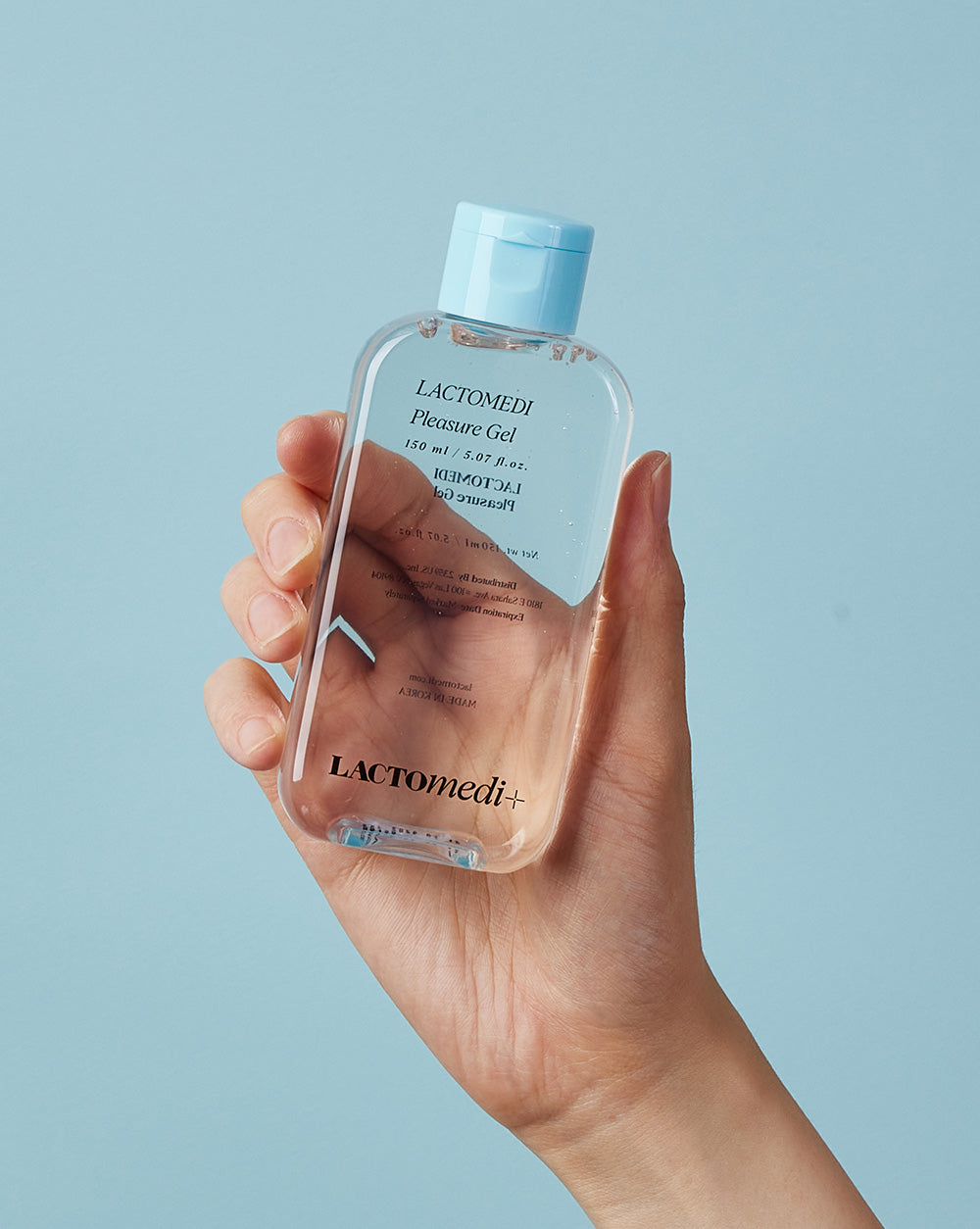 a hand holding the pleasure gel bottle